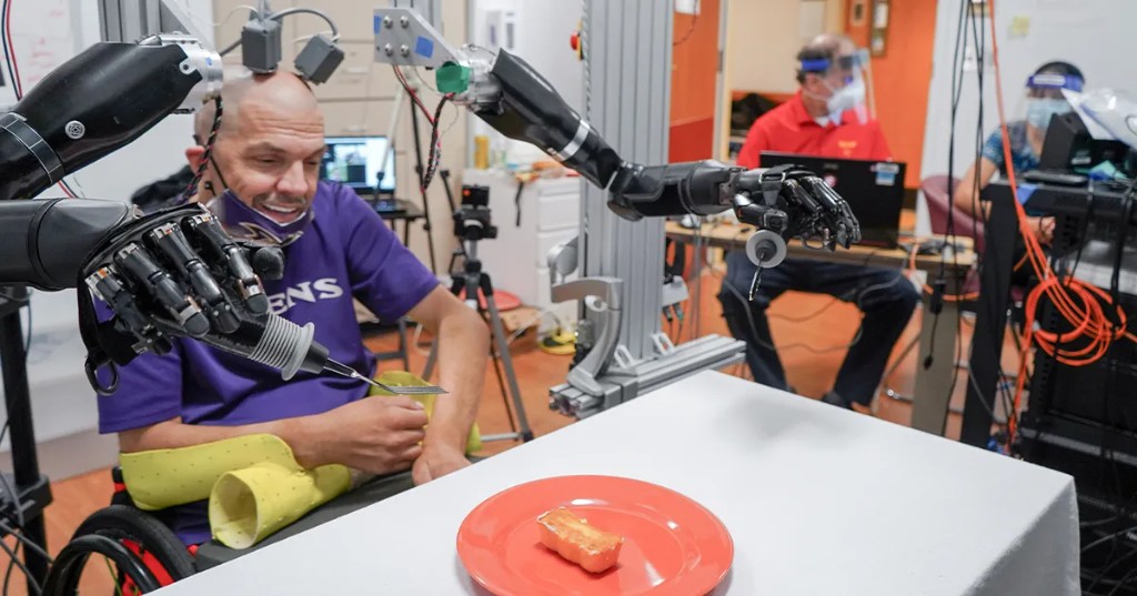 Person using a brain-computer interface to control robotic arms